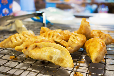 Deep fried gyoza, leave on iron mesh, it's hot and ready for sale at Khlong Lad Mayom Market, Bang Ramat Subdistrict, Taling Chan District, Bangkok, Thailand.の写真素材