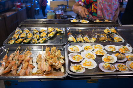 Grilled Salmons, Grilled Scallops with Garlic and Butter, Grilled mussels with Garlic and Butter at Khlong Lad Mayom Market, Bang Ramat Subdistrict, Taling Chan District, Bangkok, Thailand.の写真素材