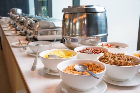 asian buffet such as fried garlic, fried pork, fried nut eat with boiled rice and others food in heated tray.の写真素材