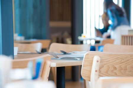 selected focus on wood chair in the modern restaurant , with blurred background of a couple customer.の写真素材