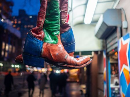 Colorful Cowboy boots hanging in urban retail area.の写真素材