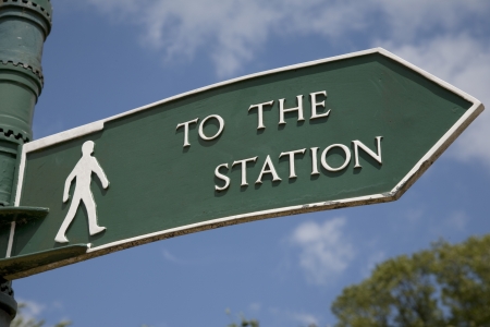 Green Station Sign against Blue Sky Backgroundの写真素材