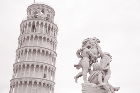 18th Century Fountain with Angels - Fontana dei Putti and Leaning Tower of Pisa in Piazza dei Miracoli Square, Pisa, Italy in Black and White Sepia Toneの写真素材