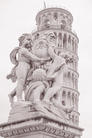 Fountain with Angels - Fontana dei Putti 18th Century and Leaning Tower of Pisa in Piazza dei Miracoli Square, Pisa, Italy in Black and White Sepia Toneの写真素材