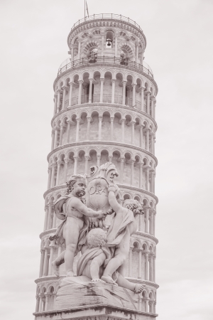 Fountain with Angels - Fontana dei Putti 18th Century and Leaning Tower of Pisa in Piazza dei Miracoli Square, Pisa, Italy in Black and White Sepia Toneの写真素材