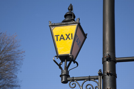 Yellow Taxi Sign against Blue Sky Backgroundの写真素材