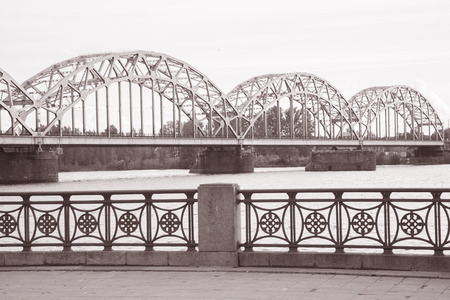 Railway Bridge and Banks of River Daugava, Riga, Latvia in Black and White Sepia Toneの写真素材