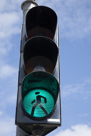 Green Pedestrian Traffic Light Sign against Blue Skyの写真素材