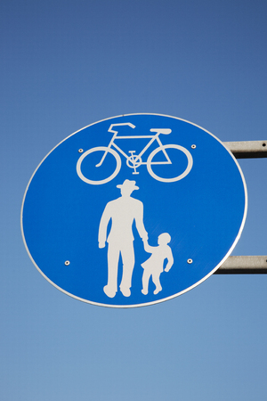 Blue and White Pedestrian and Cycling Sign against Blue Sky Backgroundの写真素材
