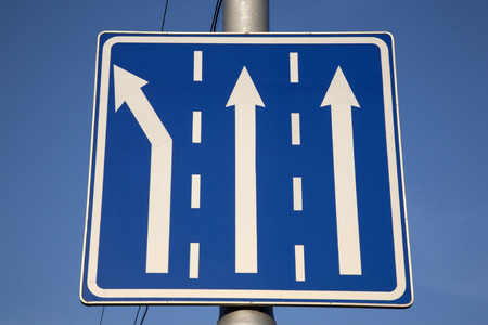 Direction Arrow Sign against Blue Sky Backgroundの写真素材