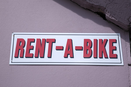 Rent a Bike Sign on Stone Wallの写真素材