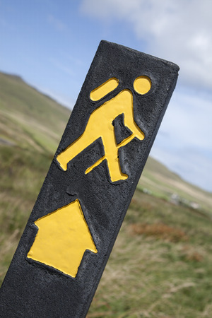 Yellow Hiking Sign with Rural Backgroundの写真素材