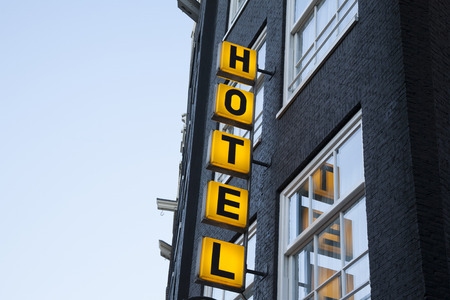 Illuminated Hotel Sign with Building Facadeの写真素材