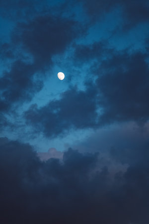 Cloudy first quarter moon in the eveningの写真素材