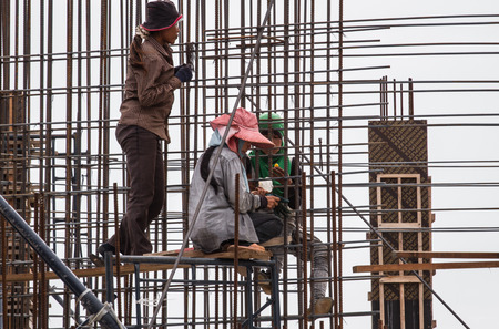 Bangkok, Thailand - July 27, 2014  Workers make reinforcement for concrete wall before sunset  on a...