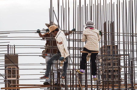 Bangkok, Thailand - July 27, 2014  Workers make reinforcement for concrete wall before sunset  on a...