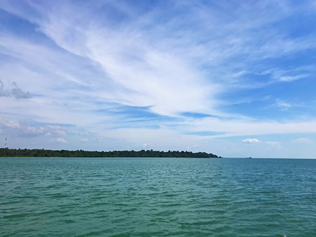 Blue sky with cloud and green sea with islandの写真素材