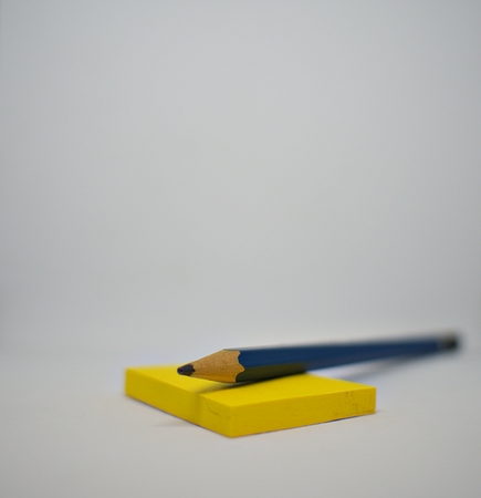 A sticky note and the used pencil on the white backgroundの写真素材
