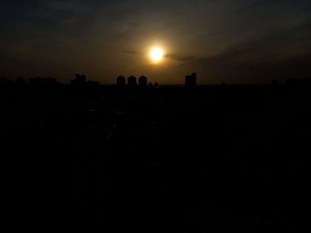 Silhouette cityscape of the dawn with a sky, cloud and the circle sunの写真素材