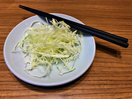 The slice cabbage placed on the white plate with chop stick waiting for dressing sauceの写真素材