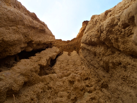 The close up shot from the ground to the texture of the earth pillar with sky and cloud background, Nan, Thailandの写真素材