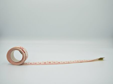 Isolated side shot on the white measuring tape with red indicator that show both cm and inches