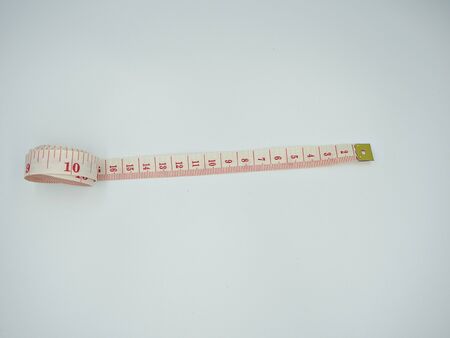 Isolated top shot on the measuring tape that have red cm and inches indicator on the whiteの写真素材