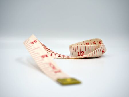Close up shot on the measuring tape with white background and the lose endの写真素材