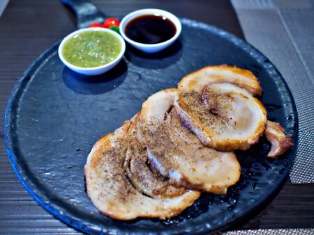 Slides of Japanese Style Chashu pork on the black plate with spicy and sweet sauceの写真素材