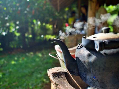 Steam fly out of the old kettle boiling on the old stove in Chiangmai, Thailandの写真素材