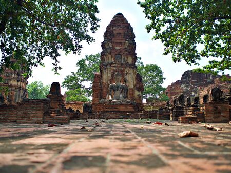 The old buddha statue and ruin of pagaoda at Wat Mahathat in Ayutthaya, Thailandの写真素材