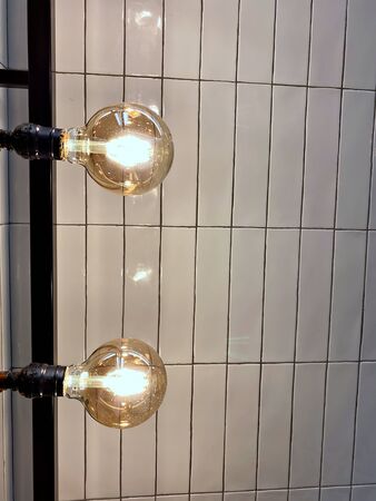 The light bulbs that lit in the hanging wall with ceramic wallの写真素材