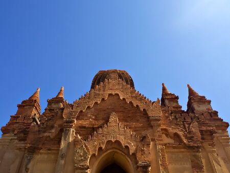 The ancient temple with blue sky and flare of sun in Bagan, World Heritage site, Myanmarのeditorial素材
