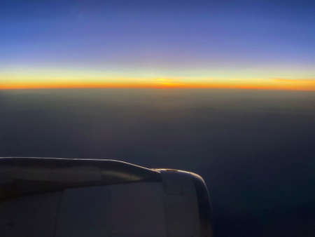The airplane jet engine and the sunset sky at horizonの写真素材