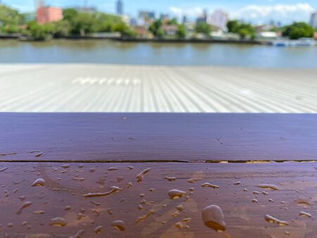 The splash of water drop on the wodden table with blur background for placking objectの写真素材