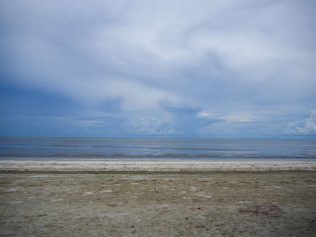 The cloudy sky and the reflection of it in the sea beach at Kuiburi, Thailandの写真素材