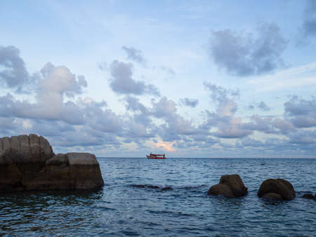 The sea rock and the wave of sea with the sunse horizon in Koh Tao, Thailandの写真素材