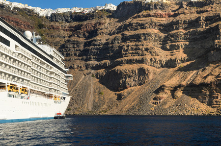 A cruising boat anchored in front of Santorini island, Greeceの写真素材
