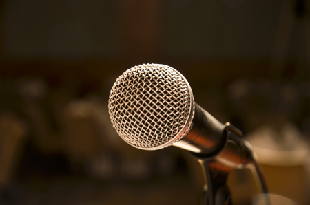 A close-up microphone on stage with blur backgroundの写真素材