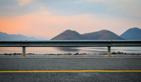 A photo of the road near the dam with sunset sceneの写真素材