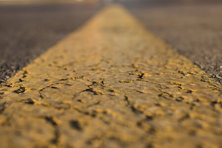 Yellow leading line on the asphalt road while there is work on it.