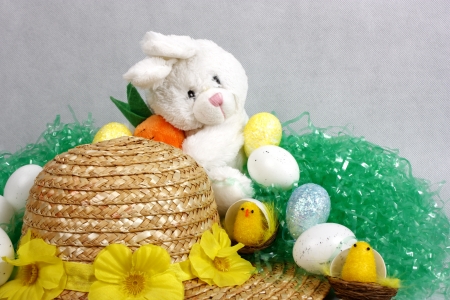 An image showing the concept of Easter with a bunny and bonnet surrounded by eggs and chicksの写真素材