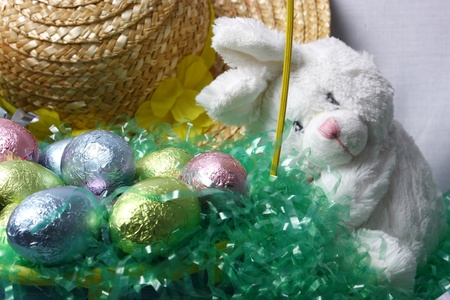 An easter bunny looking after a basket full of eggsの写真素材