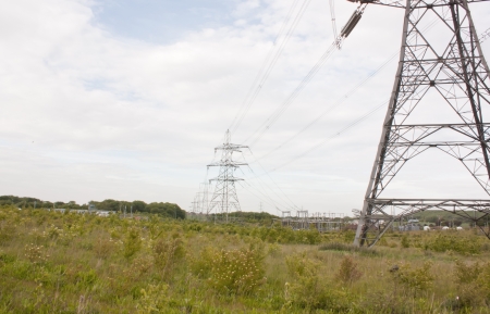 A landscape view of electricity pylons lined up across an open fieldの写真素材