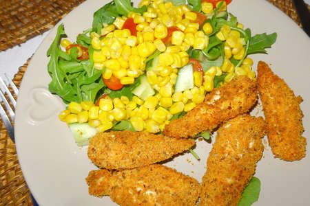Golden chicken goujons with Sweetcorn and saladの写真素材