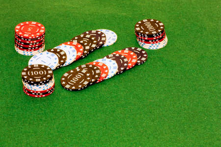 Piles of gambling tokens on a green backgroundの写真素材