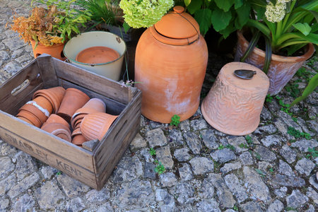 A wooden crate filled with flower pots on a stone surfaceの写真素材