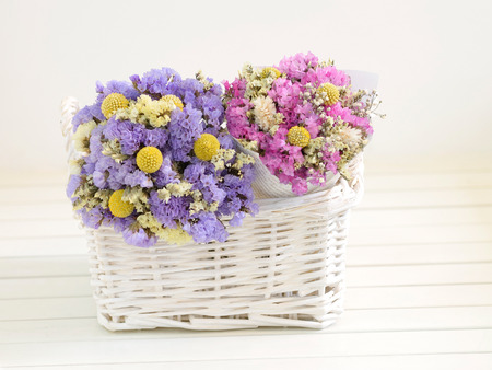 Two small bouquets of dried flowers put into a white basket の写真素材