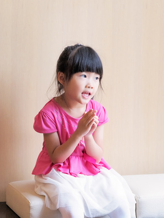 The girl puts the palms together and hopes something happened の写真素材