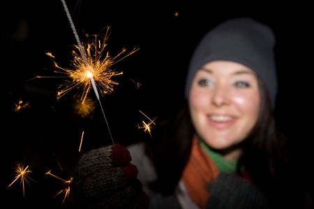 a woman holding a sparkler at  firework の写真素材